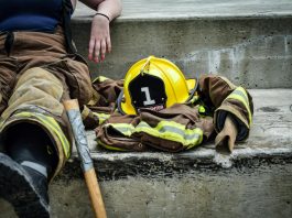 Can You Sue Your Employer in Virginia? Understanding Workers’ Comp Limits Firewoman taking a break on concrete steps with gear and helmet nearby.