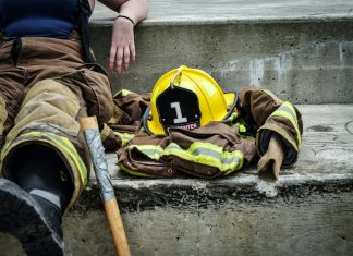 Can You Sue Your Employer in Virginia? Understanding Workers’ Comp Limits Firewoman taking a break on concrete steps with gear and helmet nearby.
