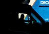 Can You Sue a Trucking Company for Driver Error? Silhouette of a driver in a vehicle with a blue industrial backdrop, illustrating transportation.