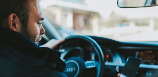 The Dangers of Distracted Driving: Can You Sue a Negligent Driver? man holding black smartphone