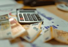 How Debt Consolidation Loans Work A calculator sitting on top of a pile of money