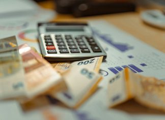 How Debt Consolidation Loans Work A calculator sitting on top of a pile of money