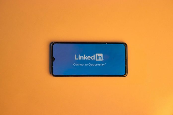 Photo by Shantanu Kumar Smartphone showing LinkedIn login on vibrant orange background, symbolizing connectivity.