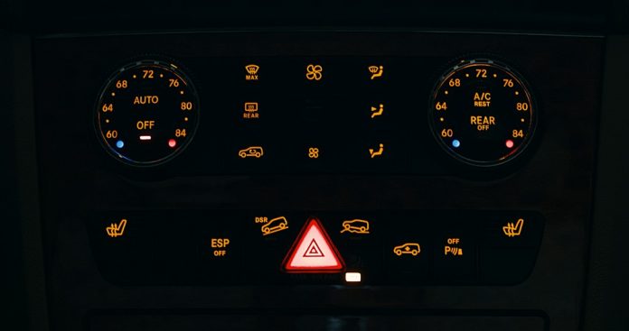 Dashboard controls of a vehicle illuminated at night.