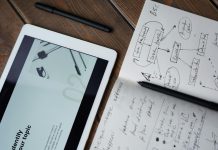 Gear Up Your Game, Promote Your Name with Totally Branded Digital and handwritten brainstorming tools on a wooden desk, ideal for business and study contexts.