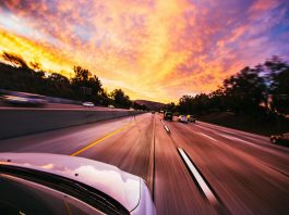 Using a Car Accident Settlement Calculator the Right Way Motion blur of cars speeding on an Irvine highway at sunset with vibrant skies.