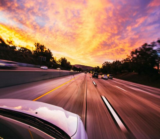 Using a Car Accident Settlement Calculator the Right Way Motion blur of cars speeding on an Irvine highway at sunset with vibrant skies.