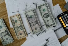 Why Payroll Mistakes Still Cost U.S. Companies Billions A workspace setup featuring cash, documents, and a calculator symbolizing financial analysis and budgeting.