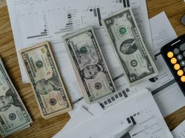 Why Payroll Mistakes Still Cost U.S. Companies Billions A workspace setup featuring cash, documents, and a calculator symbolizing financial analysis and budgeting.