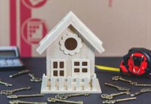 The Most Common Home Security Mistakes – and How to Avoid Them A charming wooden miniature house surrounded by antique-style keys, ideal for concepts of home ownership.
