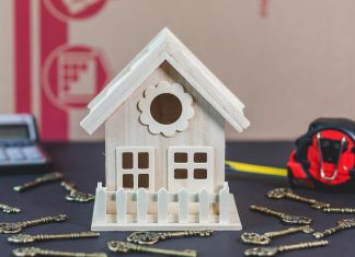 The Most Common Home Security Mistakes – and How to Avoid Them A charming wooden miniature house surrounded by antique-style keys, ideal for concepts of home ownership.