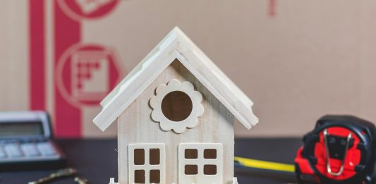The Most Common Home Security Mistakes – and How to Avoid Them A charming wooden miniature house surrounded by antique-style keys, ideal for concepts of home ownership.
