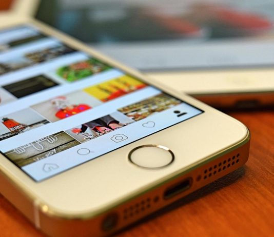 The Power of Instagram – Knowledge and Fun in Real Life A close-up view of a smartphone displaying the Instagram app on a wooden surface.