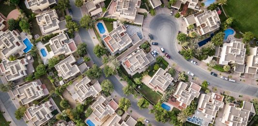 Evaluating the Legal Strength of Land Use Covenants Explore a stunning aerial view of a residential area in Dubai with lush greenery and swimming pools.