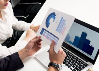 The Surprising Link Between MRO Data Quality and Worker Safety Business professionals discussing data charts and graphs in a modern office setting.