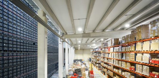 How Automated Sourcing Tools Strengthen Vendor Compliance a large warehouse filled with lots of boxes