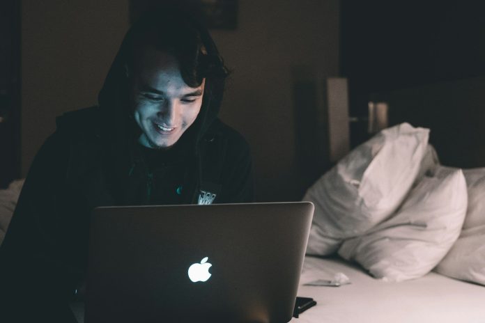 Photo by Hanny Naibaho person using MacBook in bed