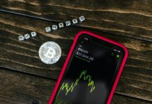 You Should Know About 5 Changes in Crypto Regulations Smartphone showing bitcoin price with a physical coin and text representing cryptocurrency investment.