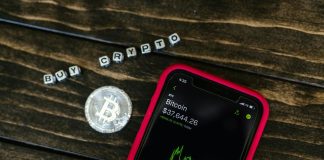 You Should Know About 5 Changes in Crypto Regulations Smartphone showing bitcoin price with a physical coin and text representing cryptocurrency investment.