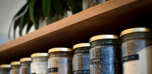 A Simple Checklist for Choosing Storage Jars from a Furniture Store in Coimbatore a shelf filled with lots of different types of spices