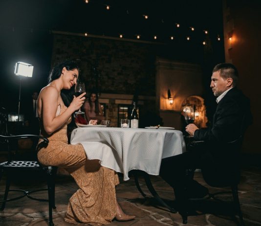 A Bayswater evening for two man sitting in front of woman holding wine glass