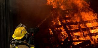 Perils Covered in Standard Fire Insurance Explained firefighter inside burning house