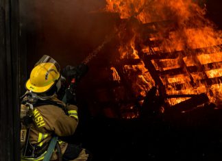 Perils Covered in Standard Fire Insurance Explained firefighter inside burning house