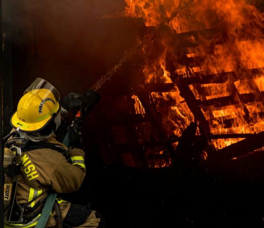 Perils Covered in Standard Fire Insurance Explained firefighter inside burning house