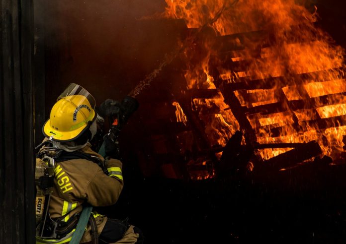 Photo by Jay Heike firefighter inside burning house