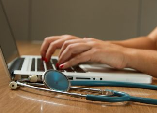 Professional Indemnity Insurance for Doctors: Protection Against Medico-Legal Risks person sitting while using laptop computer and green stethoscope near