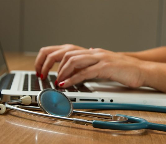 Professional Indemnity Insurance for Doctors: Protection Against Medico-Legal Risks person sitting while using laptop computer and green stethoscope near